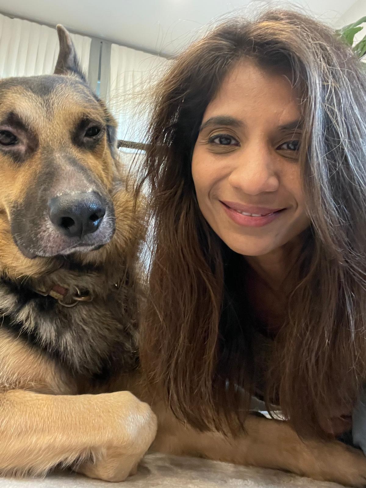 Manse M Doshi smiling at home beside her dog, Rocky